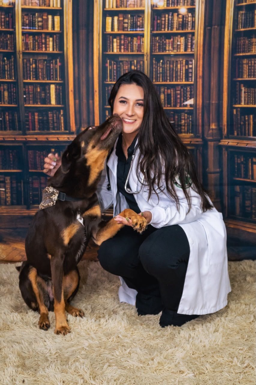 Dra. Aymee Mattozo com um cão no colo, demonstrando carinho no atendimento